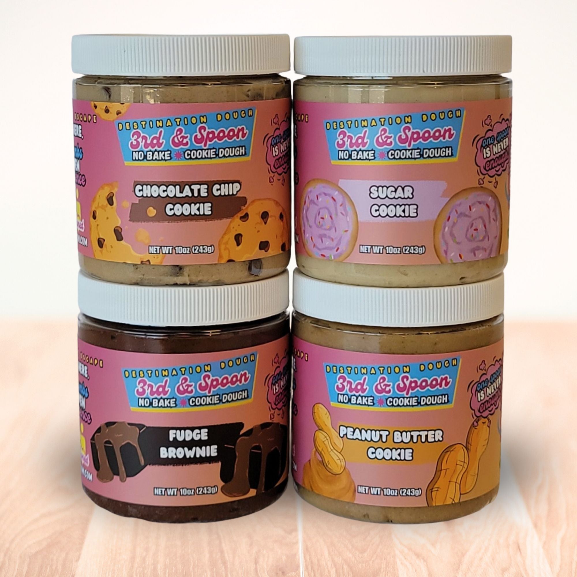Four regular jars of 3rd & Spoon edible cookie dough with different flavors on a light background.