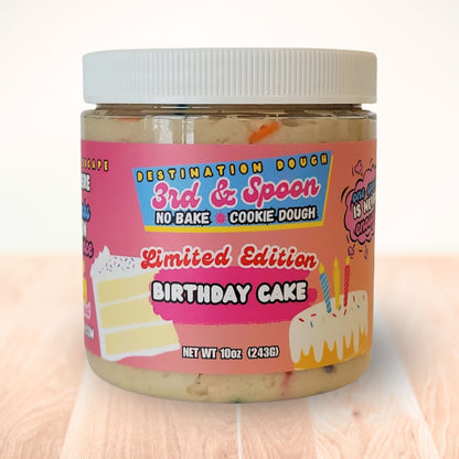 10 oz jar of 3rd & Spoon birthday cake edible cookie dough on a light wooden counter