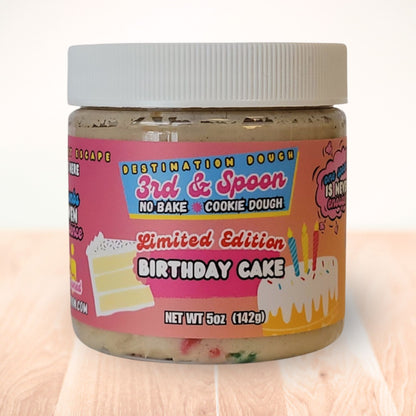 5 oz jar of 3rd & Spoon birthday cake edible cookie dough on a light wooden counter
