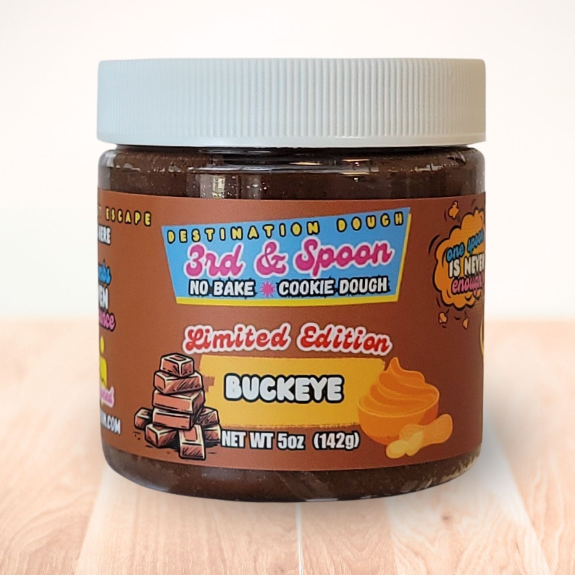5 oz jar of 3rd & Spoon buckeye edible cookie dough on a light wooden counter