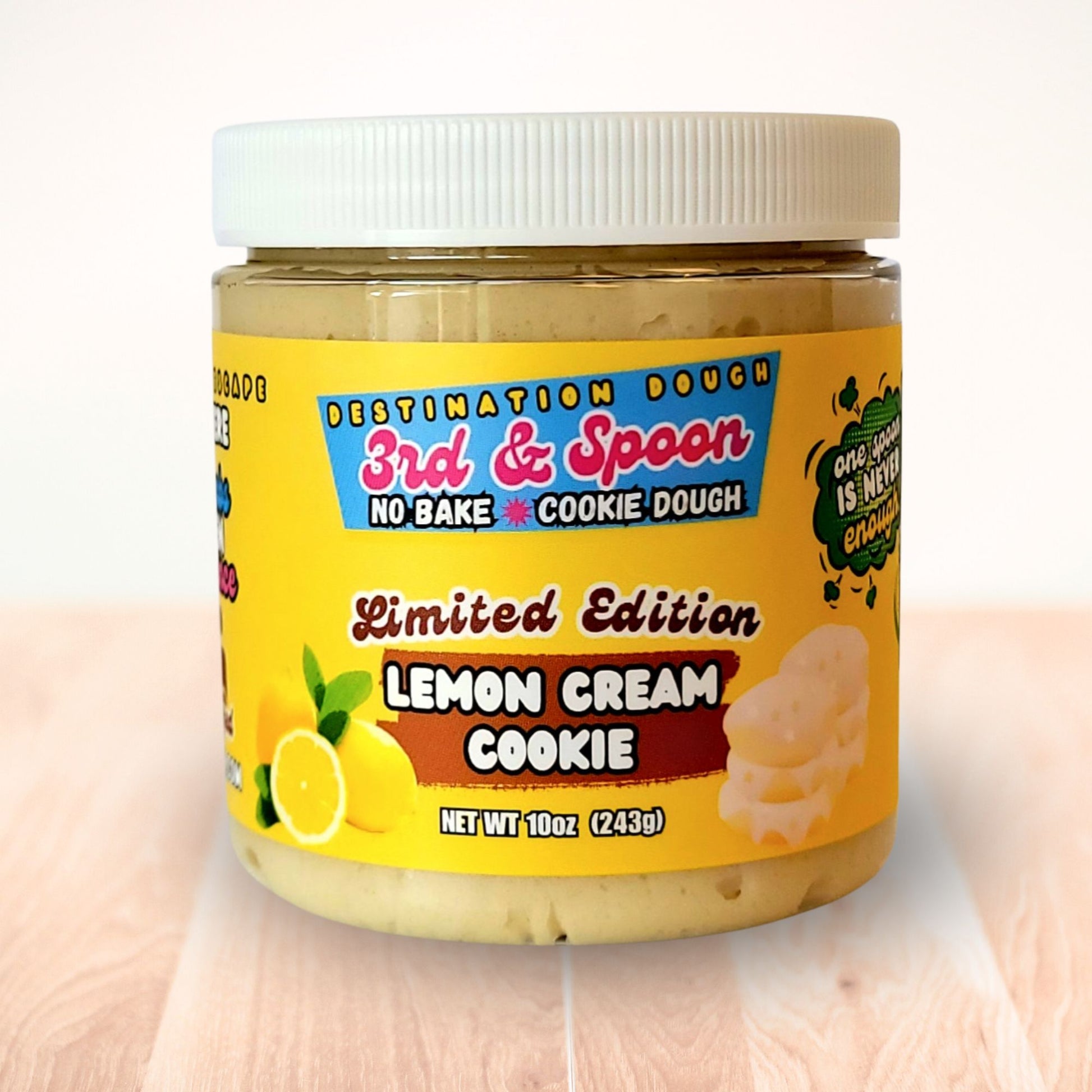 10 oz jar of 3rd & Spoon lemon cream edible cookie dough on a light wooden counter