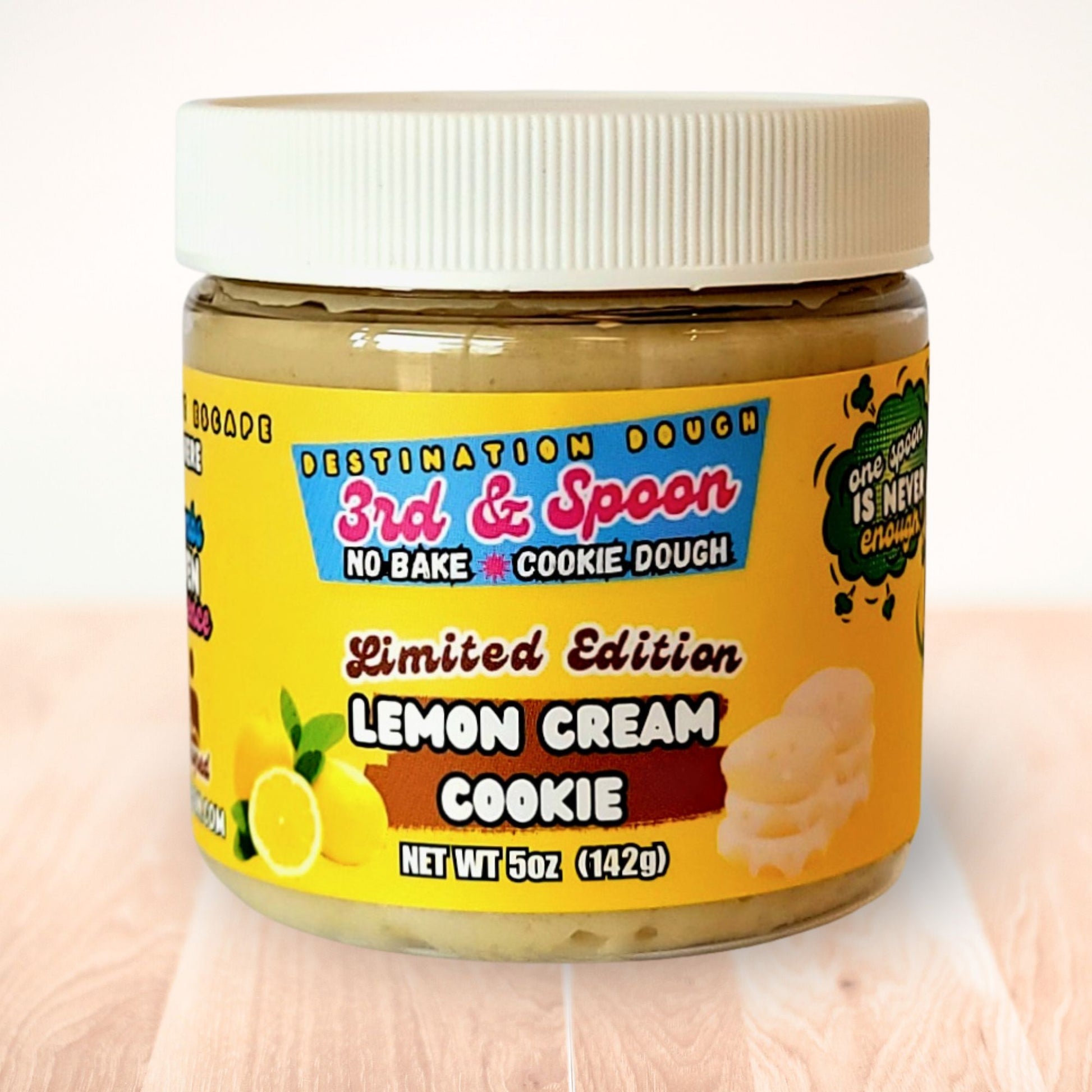 5 oz jar of 3rd & Spoon lemon cream edible cookie dough on a light wooden counter