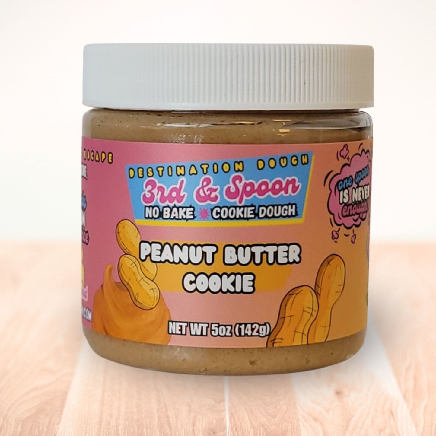5 oz jar of 3rd & Spoon peanut butter edible cookie dough on a light wooden counter