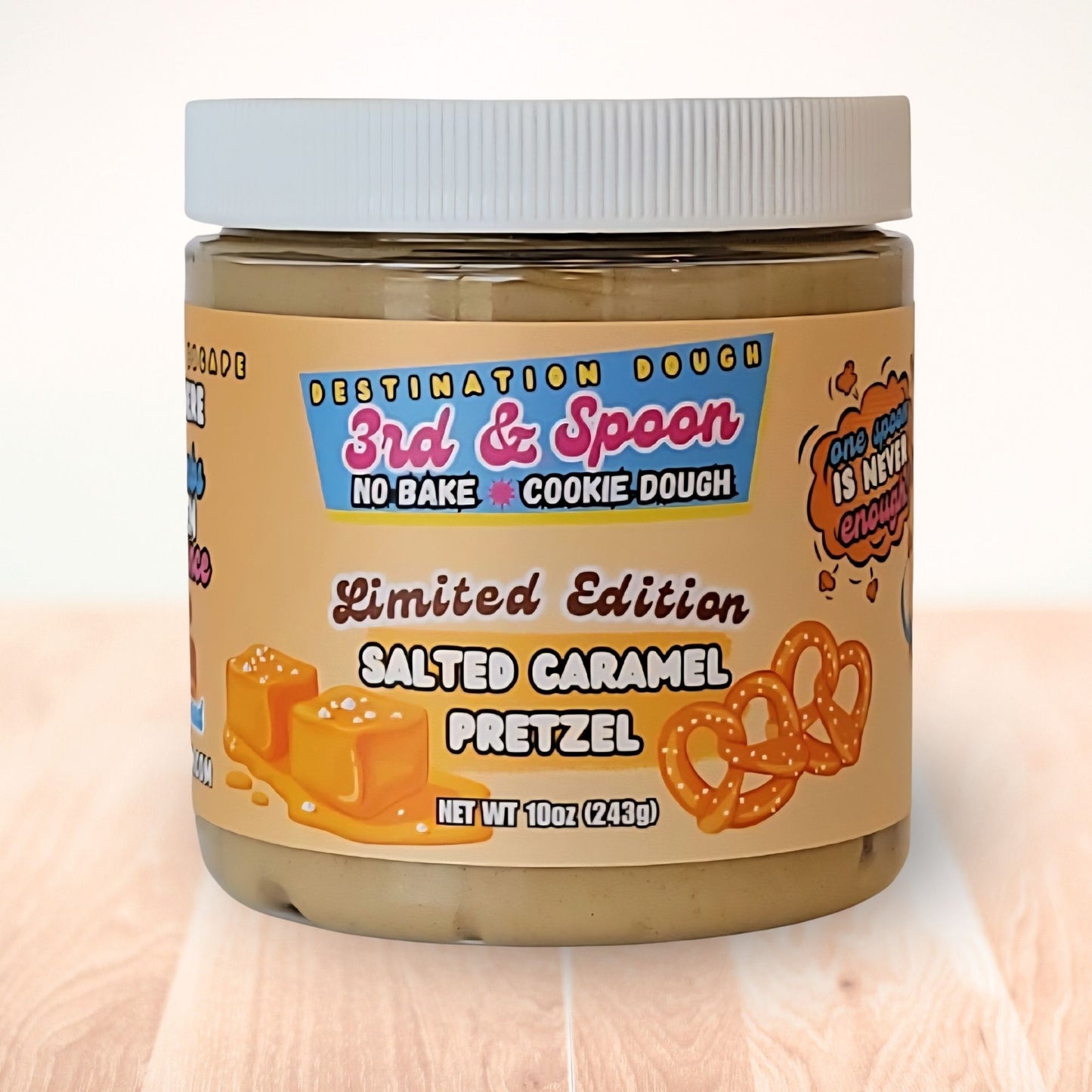 10 oz jar of 3rd & Spoon salted caramel pretzel edible cookie dough on a light wooden counter