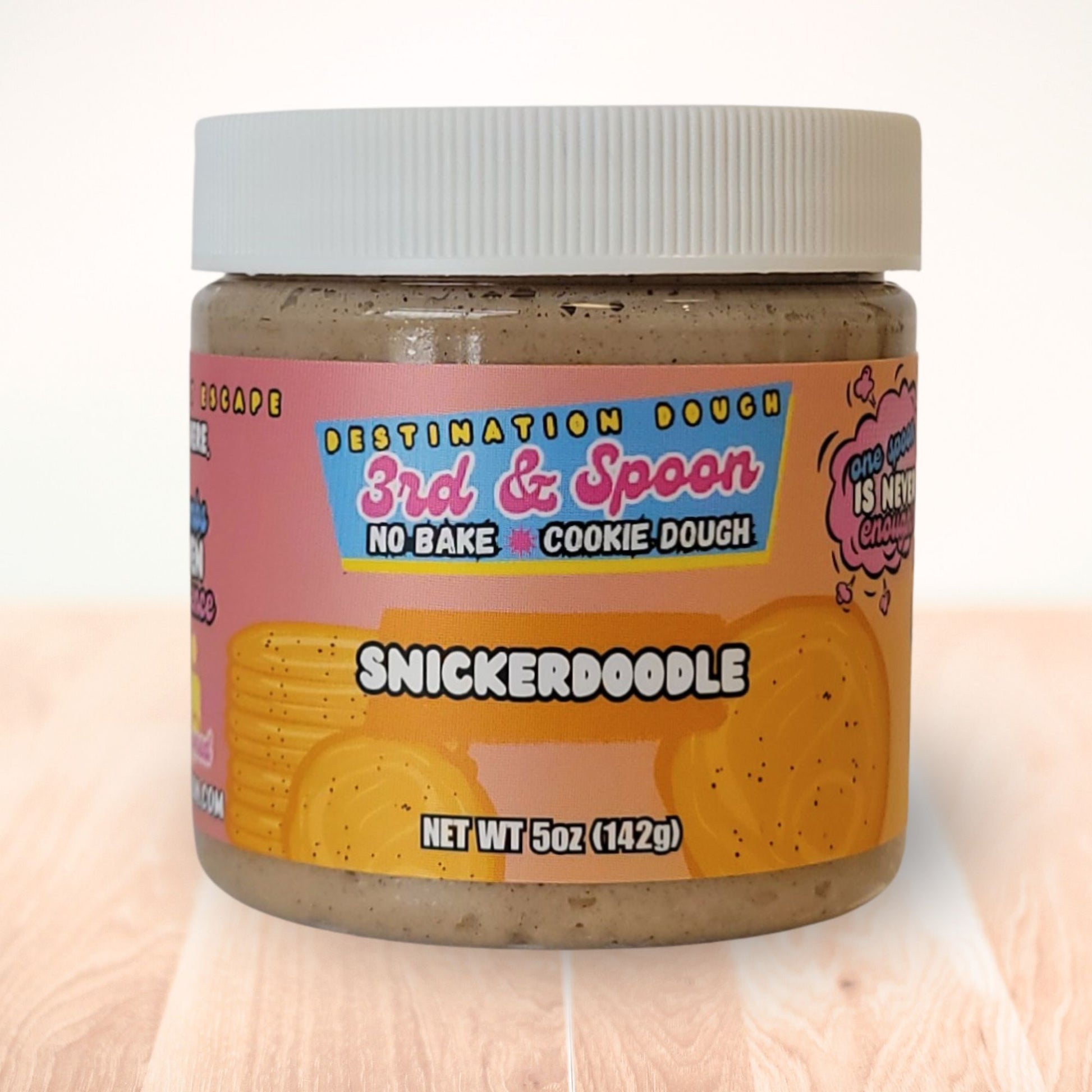 5 oz jar of 3rd & Spoon snickerdoodle edible cookie dough on a light wooden counter