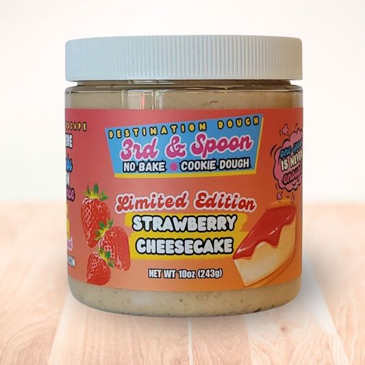 10 oz jar of 3rd & Spoon strawberry cheesecake edible cookie dough on a light wooden counter