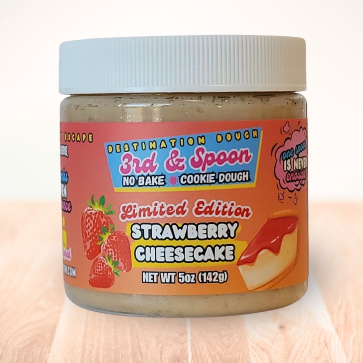 5 oz jar of 3rd & Spoon strawberry cheesecake edible cookie dough on a light wooden counter